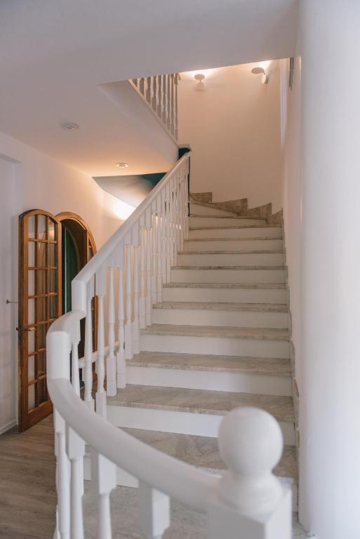 a staircase in a house with white stair railing at Mami Sabaudia Hotel in Sabaudia