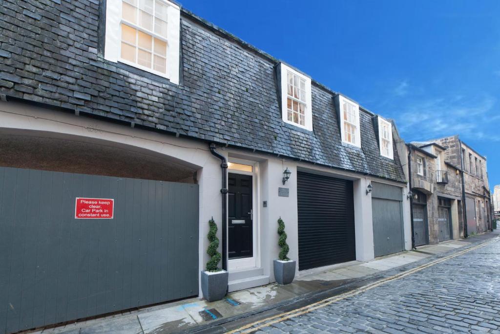 un bâtiment avec deux portes de garage dans une rue dans l'établissement Queensferry Street Lane - Fantastic 2 BR City Centre Mews House with free secure parking!, à Édimbourg