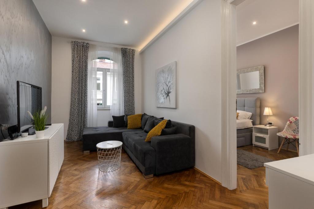 ein Wohnzimmer mit Sofa und ein Schlafzimmer in der Unterkunft Apartment LUX HOME in Rijeka