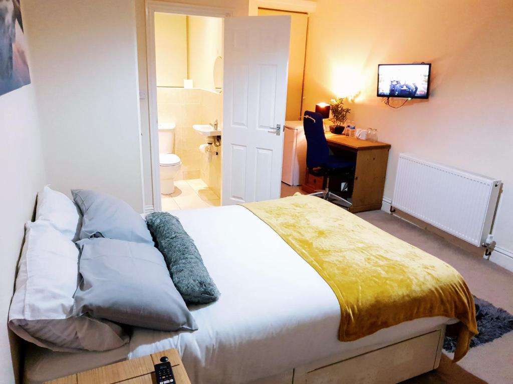 a bedroom with a bed and a desk with a computer at Highfields Town House in Huddersfield