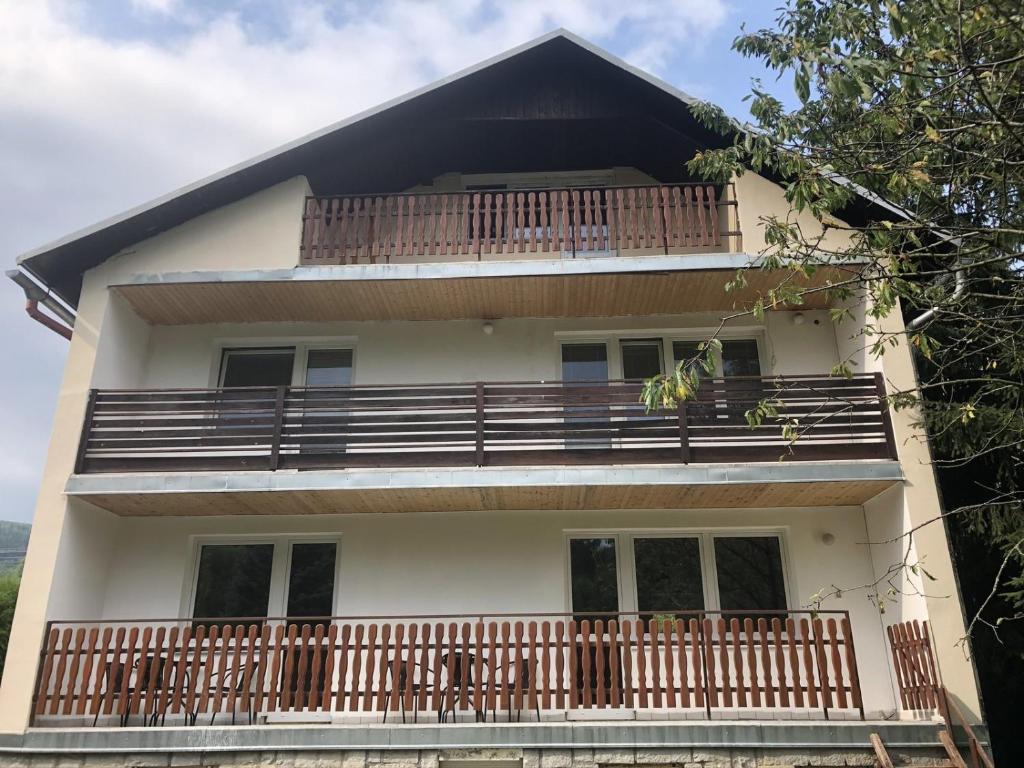 a house with a large balcony with wooden railings at Apartmány u kostela in Lipova Lazne