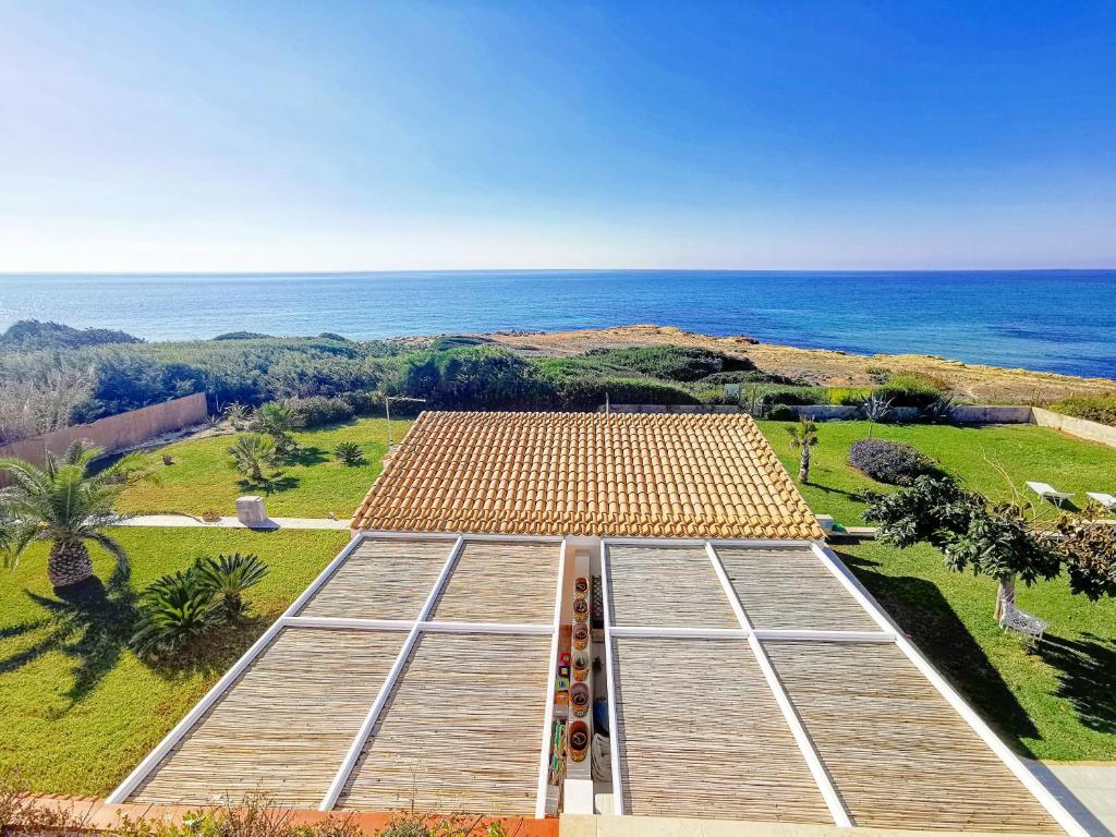 una vista sul cielo di un edificio con l'oceano sullo sfondo di TRAVELLIVING - Casa Vacanze Villa Ida, Beachfront a Punta Braccetto