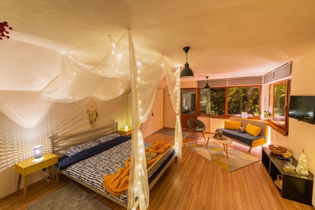 a bedroom with a canopy bed and a living room at Dragonfly Studio with GARDEN in Braşov