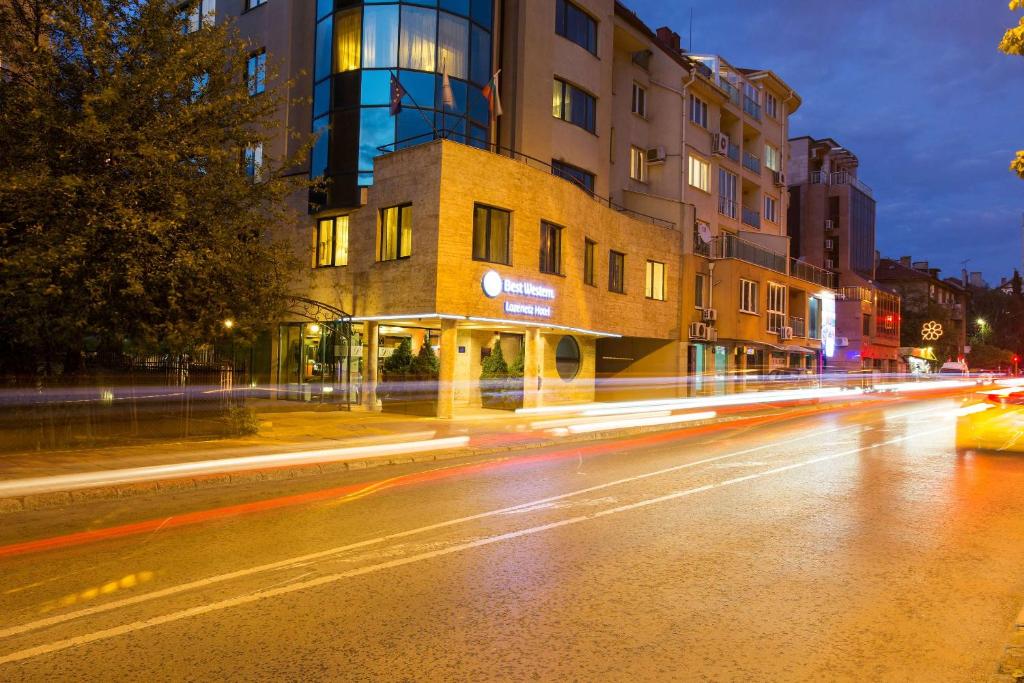 a city street at night with buildings and streaks of lights at Best Western Lozenetz Hotel in Sofia