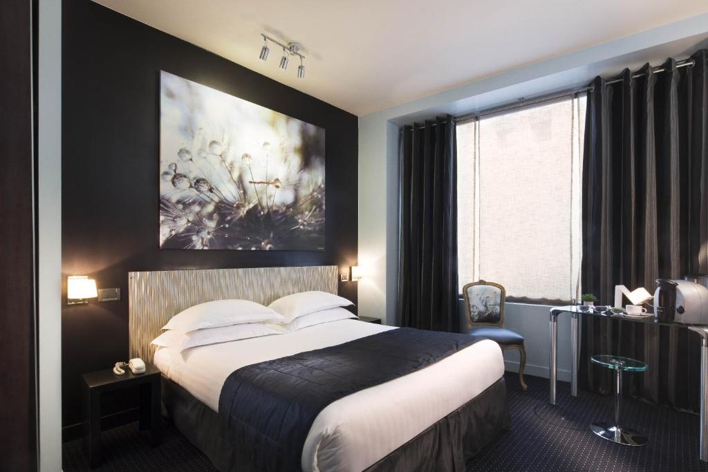 una habitación de hotel con una cama y un cuadro en la pared en Hôtel Le Fabe, en París