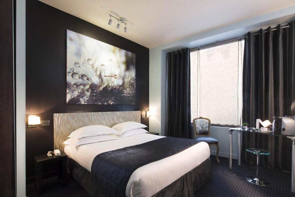 a hotel room with a bed and a painting on the wall at Hôtel Le Fabe in Paris