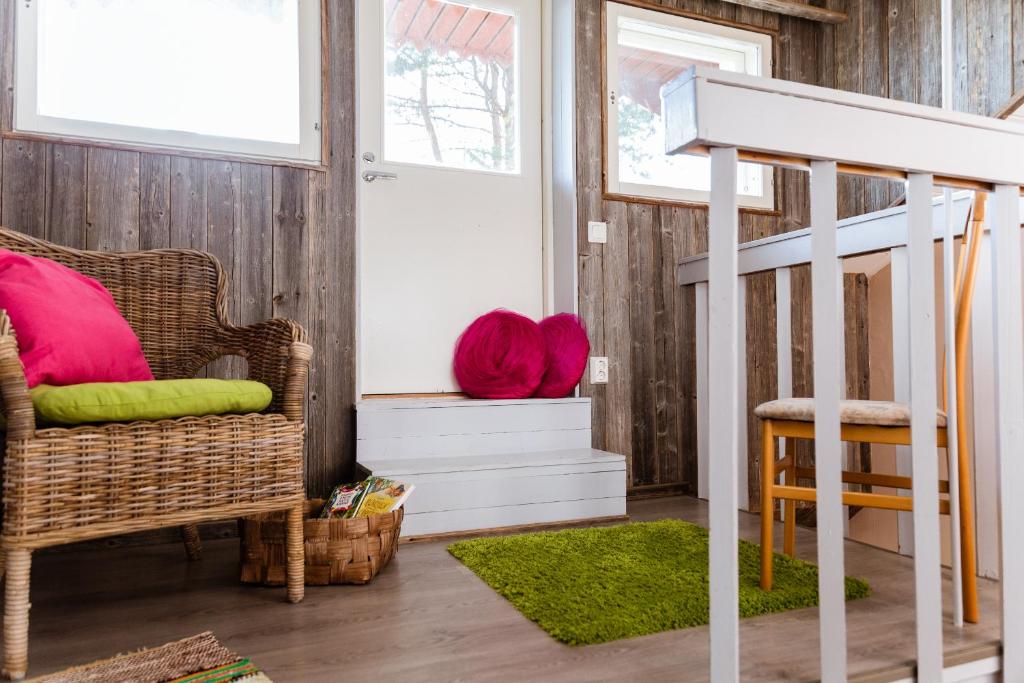 a living room with a wicker chair and a staircase at Paijan Maatilamajoitus in Ypäjä