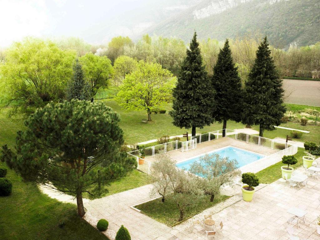 an aerial view of a garden with a swimming pool at Novotel Grenoble Nord Voreppe in Voreppe