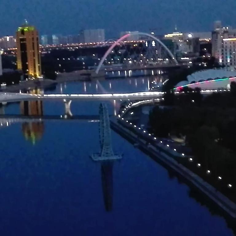 a view of a bridge over a river at night at Апартаменты на набережной 15 этаж in Astana