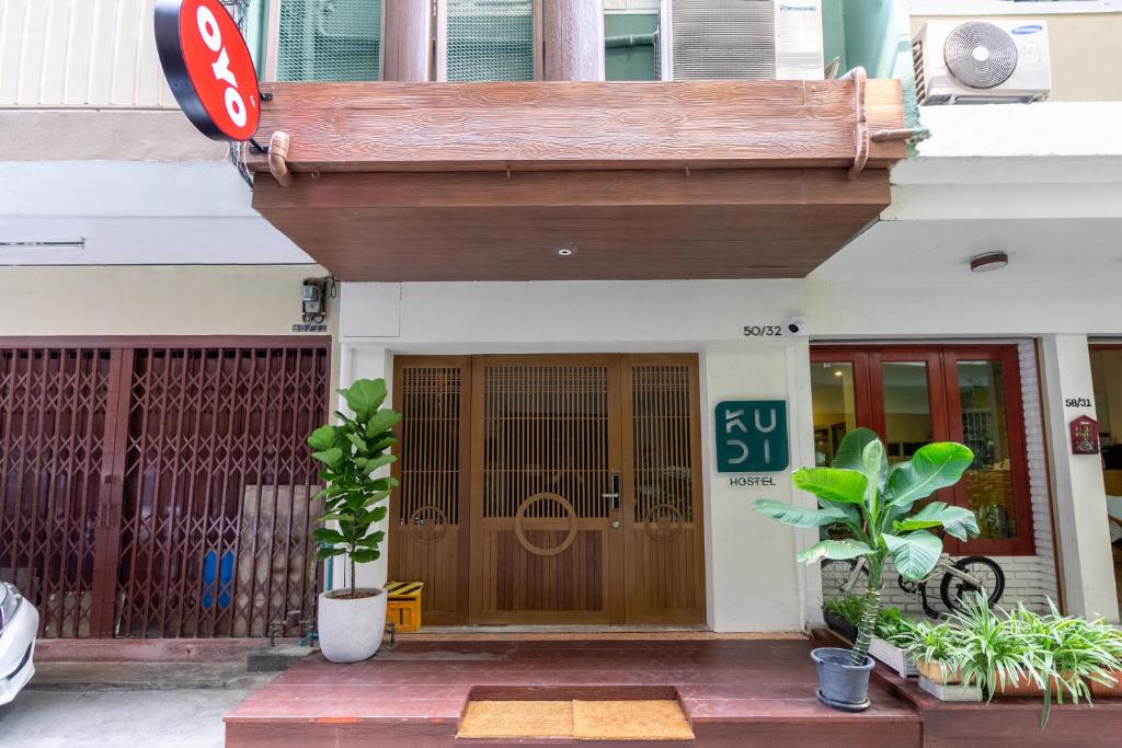 a building with a brown door with a sign on it at OYO 994 Kudi Hostel in Bangkok