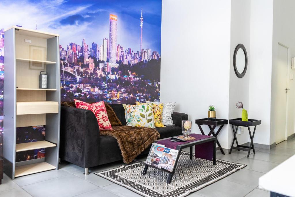 a living room with a couch and a city mural at Stunning Maboneng Precinct Studio Apartment at 12 Decades Building in Johannesburg