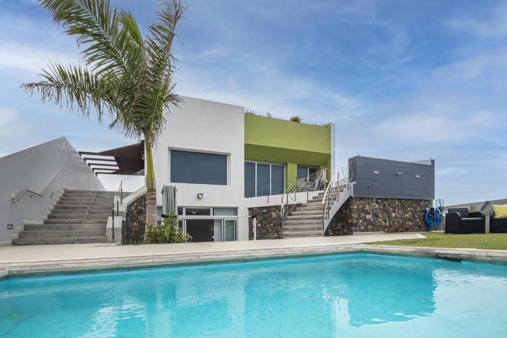 una casa con piscina frente a una casa en Casa Alsa, en La Guancha