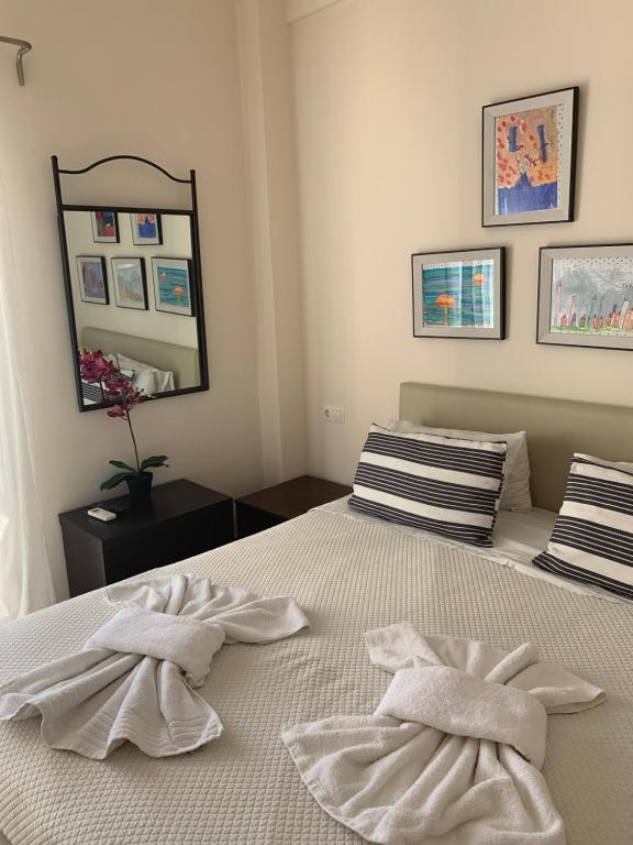 sypialnia z 2 ręcznikami na łóżku z lustrem w obiekcie Athenian cozy Apartment!!! w Atenach