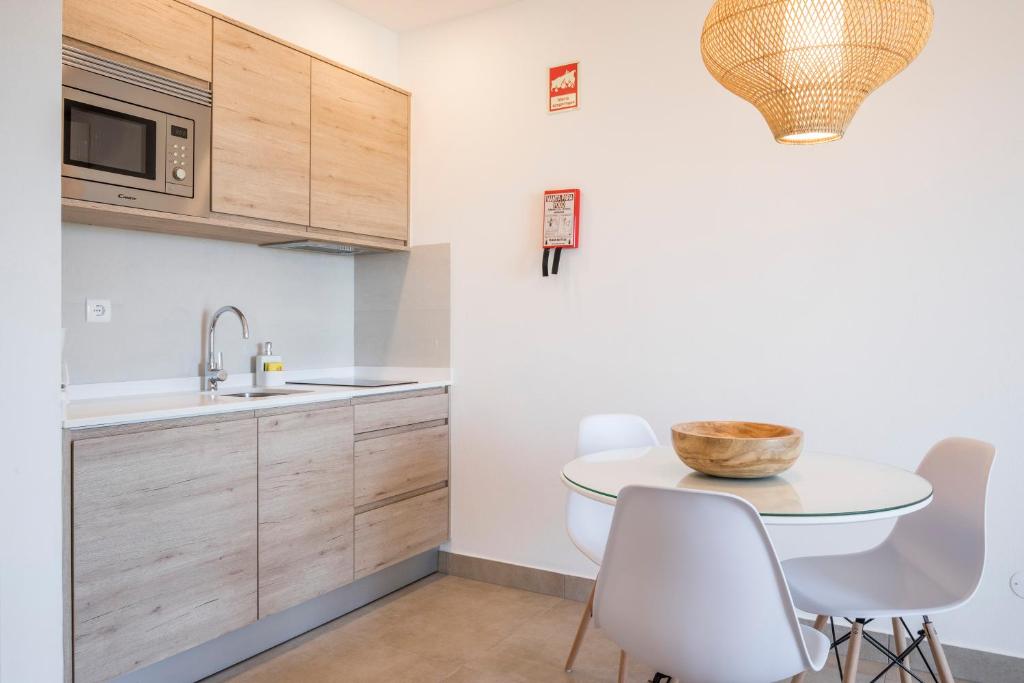 a kitchen with white cabinets and a table and chairs at Clube Porto Mos - Sunplace Hotels & Beach Resort in Lagos