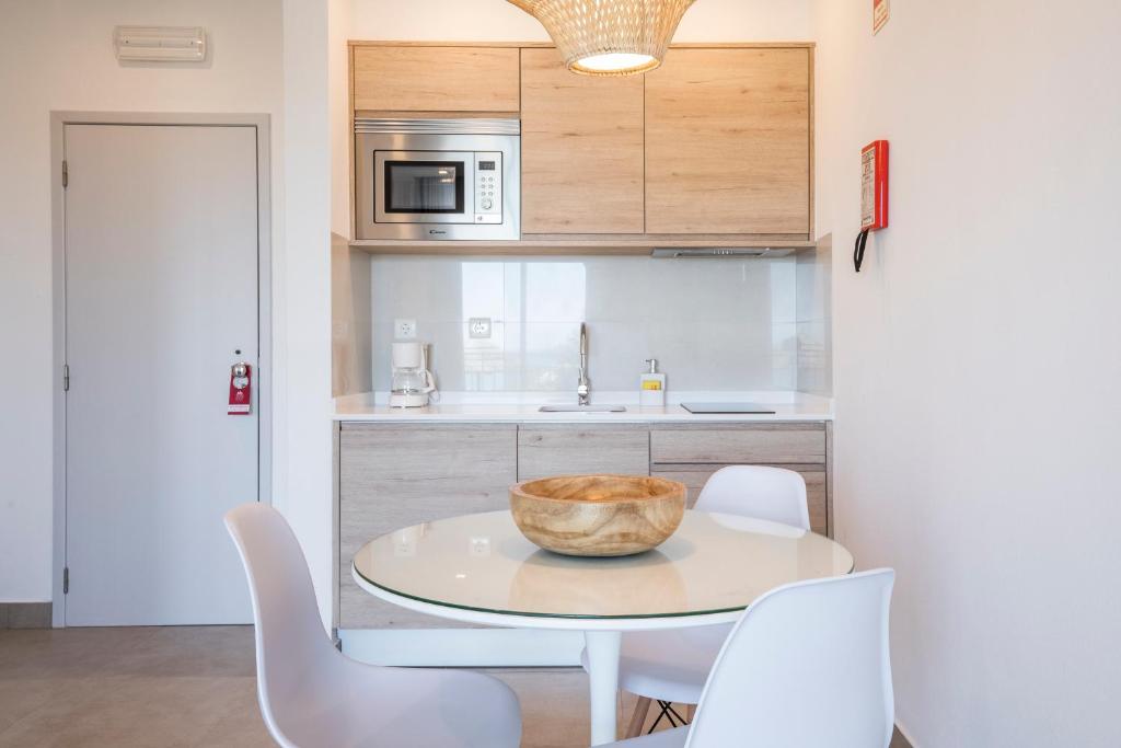 a kitchen with a table with chairs and a bowl on it at Clube Porto Mos - Sunplace Hotels & Beach Resort in Lagos