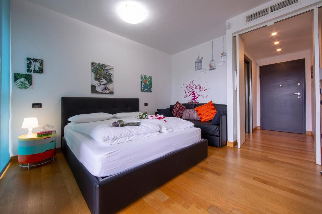 ミラノにあるTEMPORARYFLAT Parco Vittoriaのベッドルーム(大型ベッド1台、ソファ付)