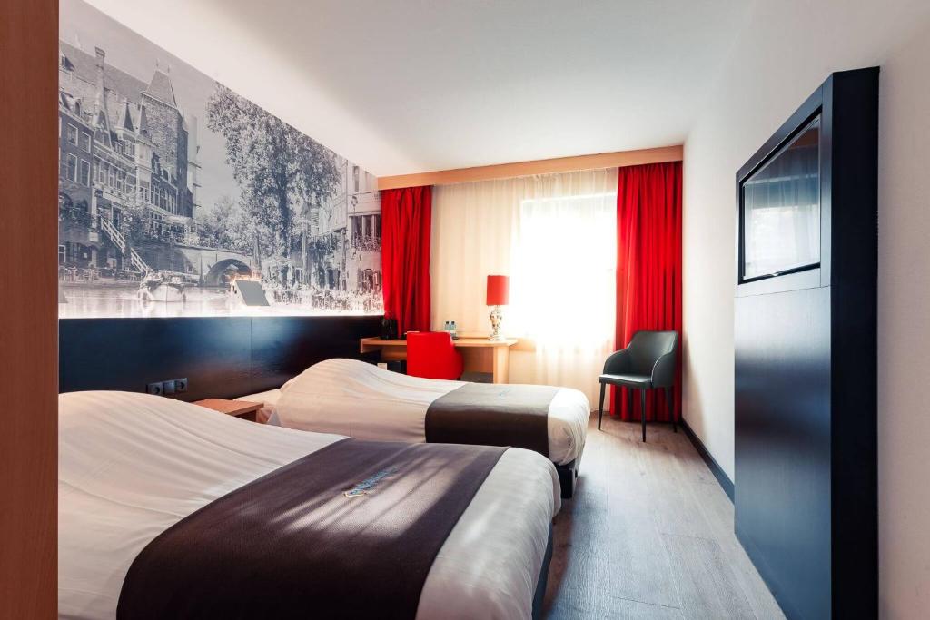 a hotel room with a bed and a tv at Bastion Hotel Utrecht in Utrecht