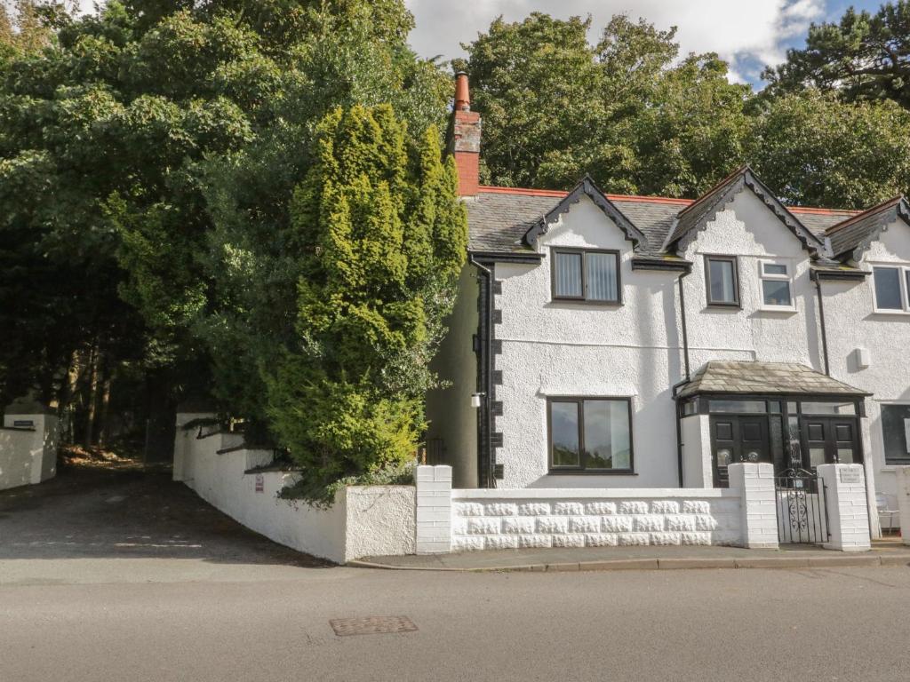 a white house with a fence in front of it at One Conway View in Colwyn Bay