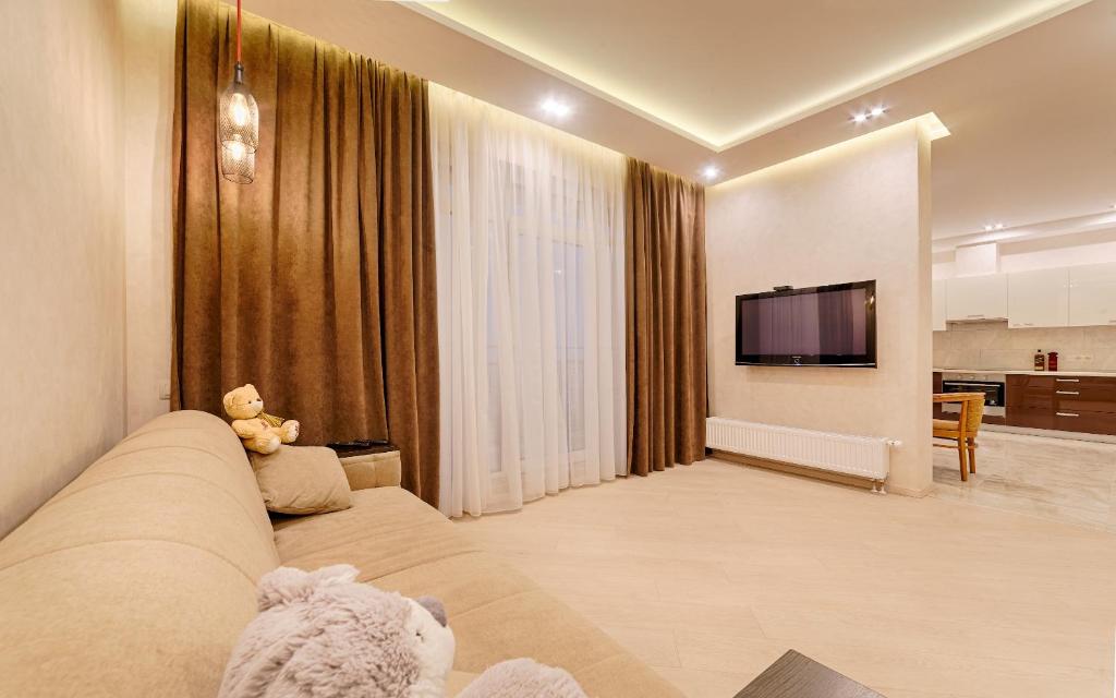 een woonkamer met een bank en een flatscreen-tv bij New apartments in Arcadia sea view in Odessa