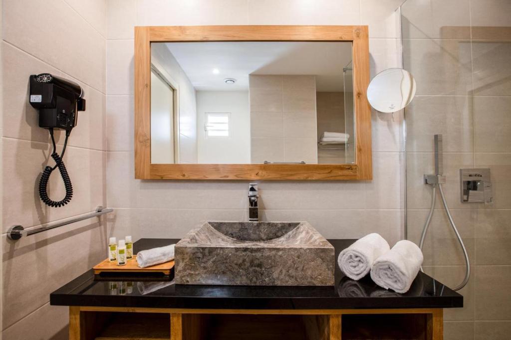a bathroom with a sink and a mirror at Orient Beach Hotel in Orient Bay