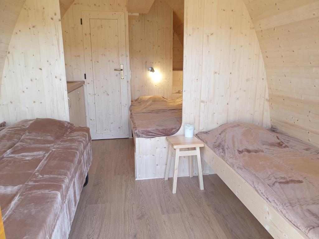 Habitación con 2 camas y una mesa pequeña. en B&B La ferme du Château de Broich en Plombières