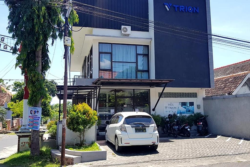 a white car parked in front of a building at Trion Homestay in Banyuwangi
