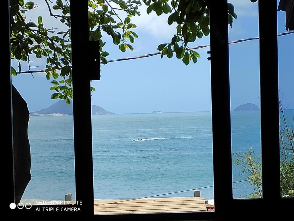 a view of the ocean from a window at Barra Beach Club CASAS in Florianópolis