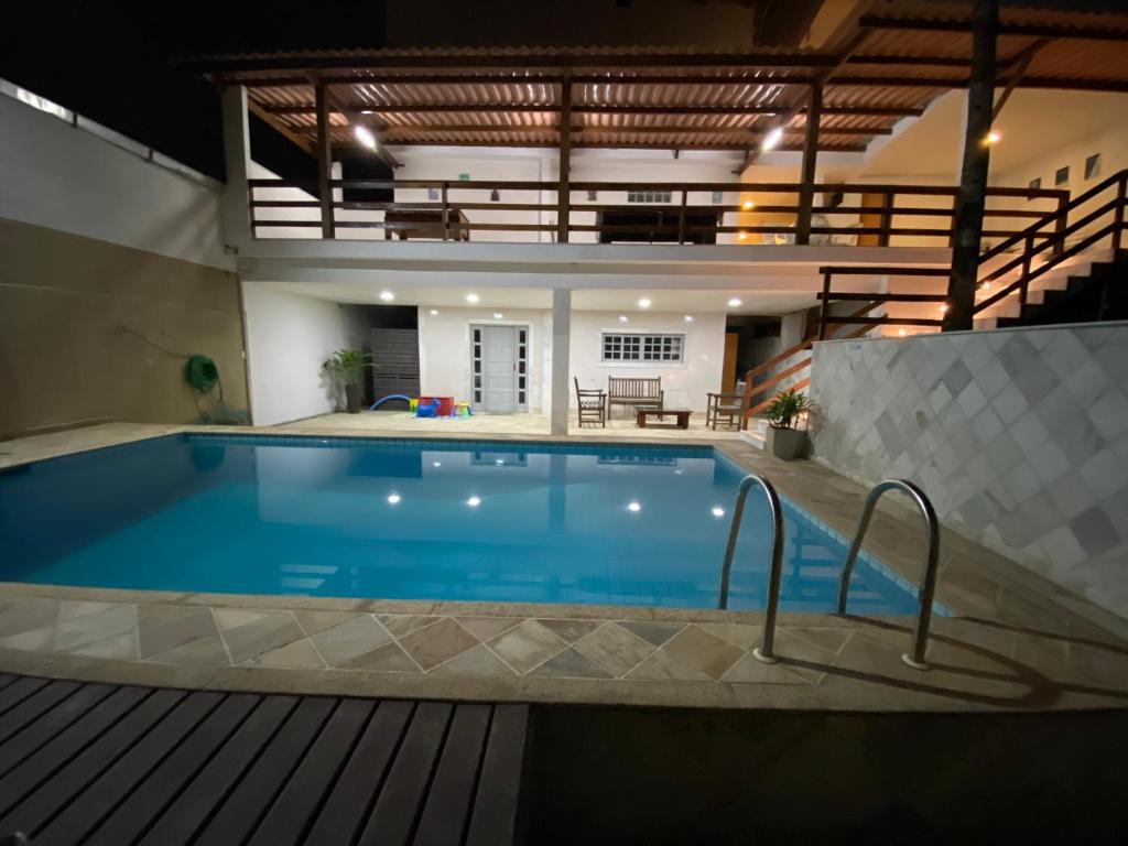 a large swimming pool in a building with a house at Residencial Lúpulos in Angra dos Reis
