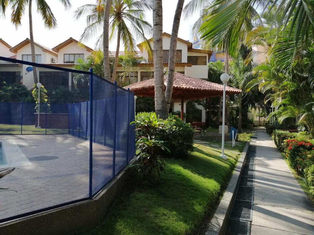 um campo de ténis em frente a uma casa com palmeiras em Casa, playa Bello Horizonte Santa Marta Colombia em Santa Marta