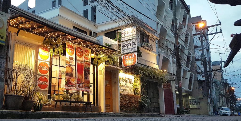 a building with signs on the side of a street at Crossroads Hostel Manila in Manila