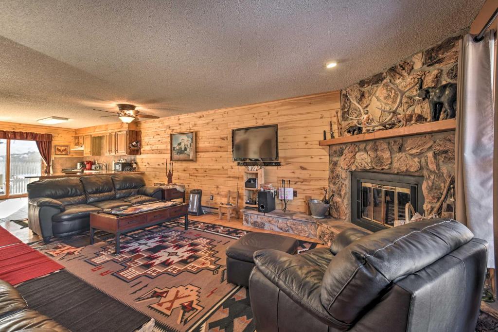 a living room with leather furniture and a fireplace at Downtown Red River Retreat with Mtn Views and Yard in Red River