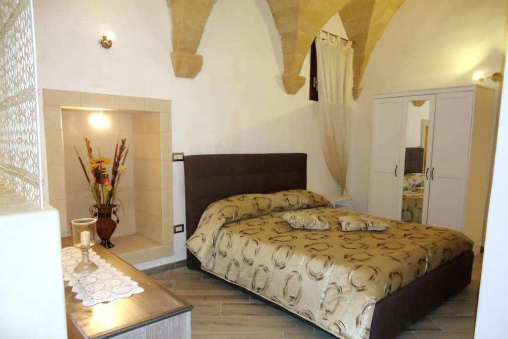 een slaapkamer met een groot bed en een tafel bij Nel Cuore di Lecce in Lecce