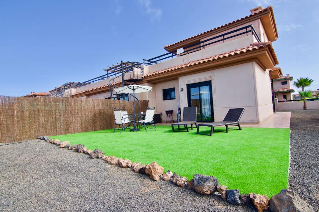 a house with a yard with green grass at The Wind's Breath, perfect for relaxing getaway in La Oliva