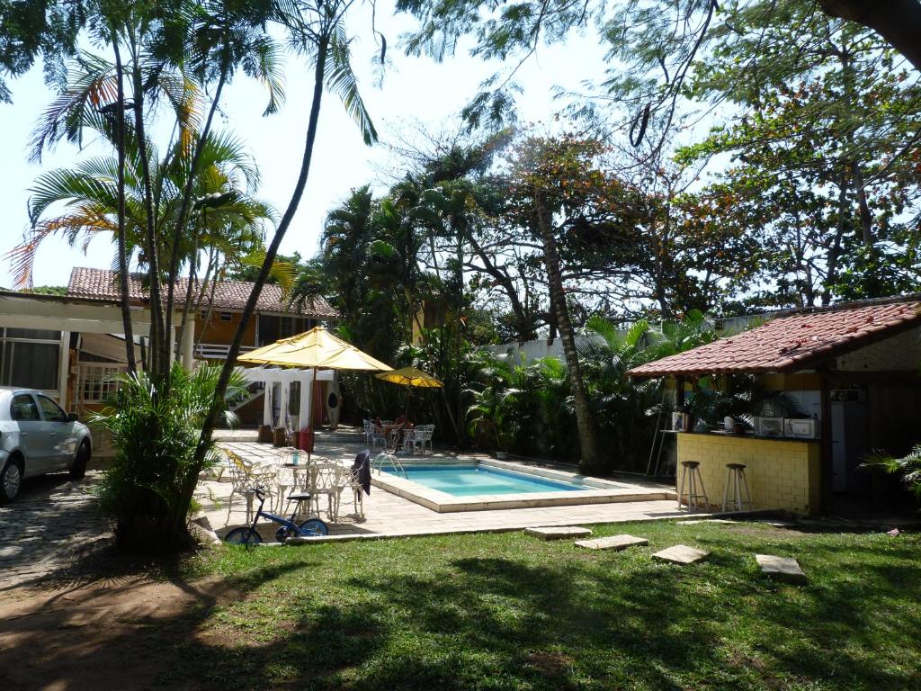 un patio trasero con piscina y una casa en Suite familiar completa, en Búzios