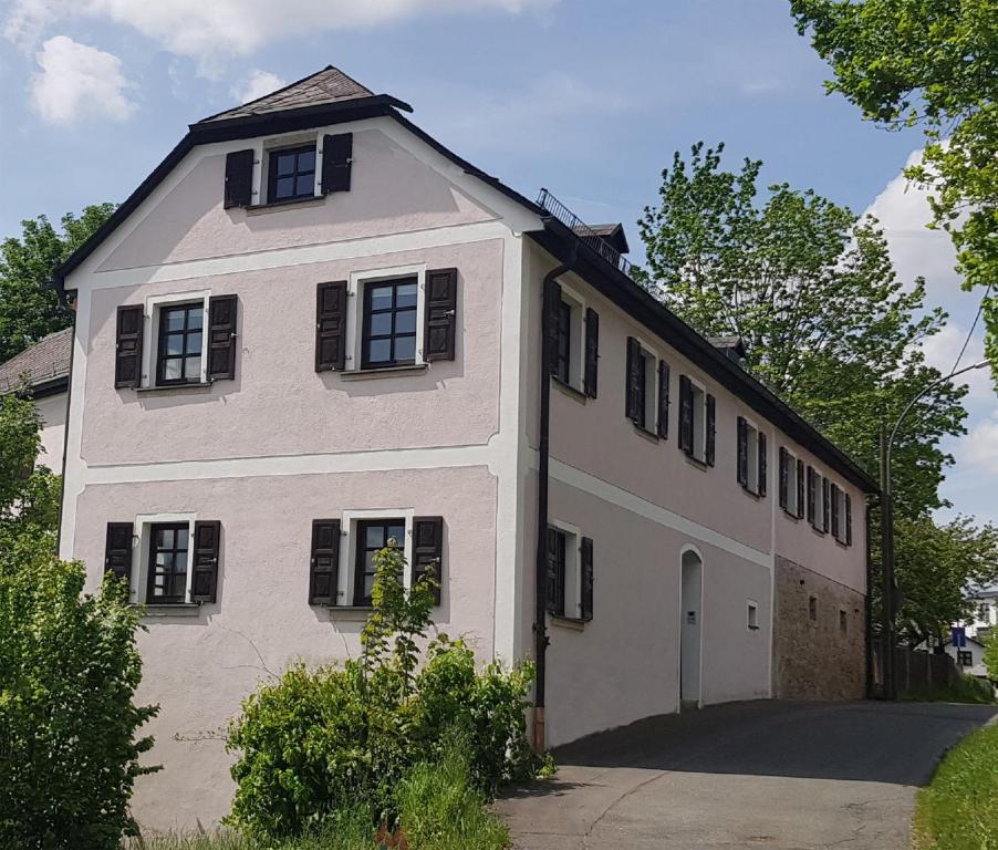 a white house with black shuttered windows at Ferienwohnungen Hafnerkarl in Falkenberg