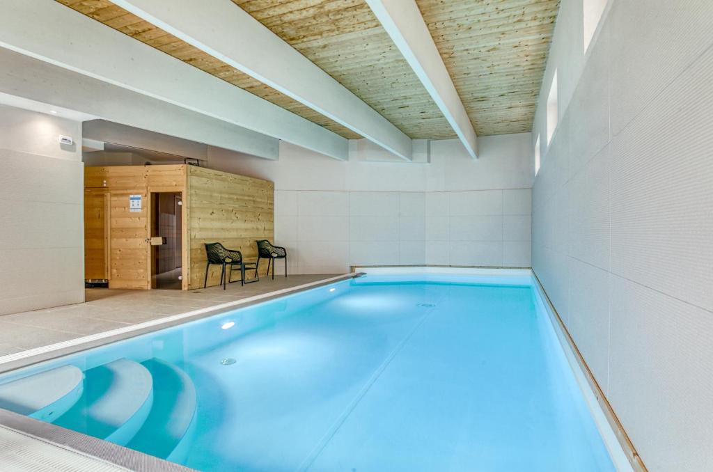 a large swimming pool in a room with at Brit Hotel Bristol Montbéliard Centre in Montbéliard