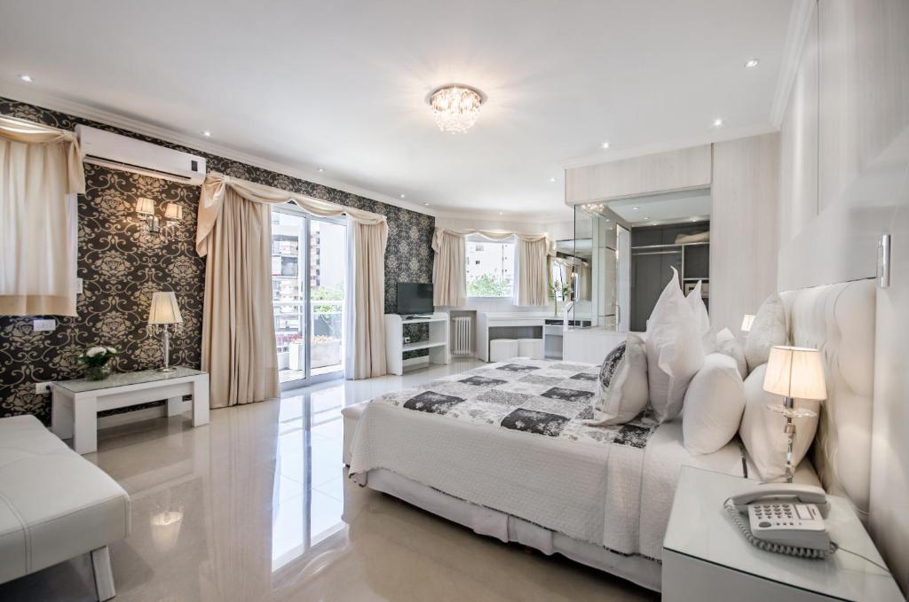 a white bedroom with a bed and a living room at Hotel Nuevo Ostende by bund in Mar del Plata