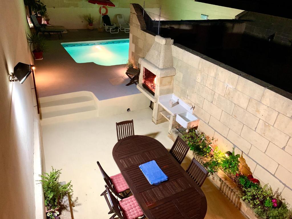 vistas a un patio con mesa y piscina en Classic Farmhouse & Private Pool, en Mġarr