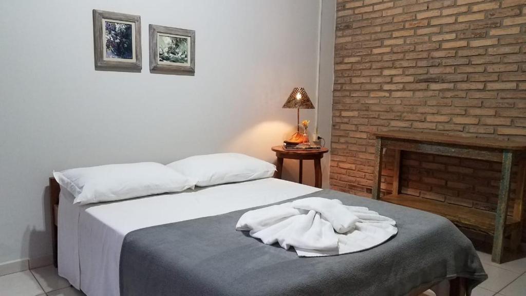 a bedroom with two beds and a fireplace at Pousada Cheiro de Mato in Bonito