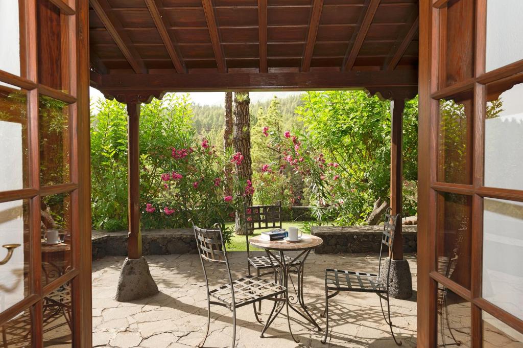 eine Terrasse mit einem Tisch, Stühlen und Blumen in der Unterkunft Casa Calimera in El Paso