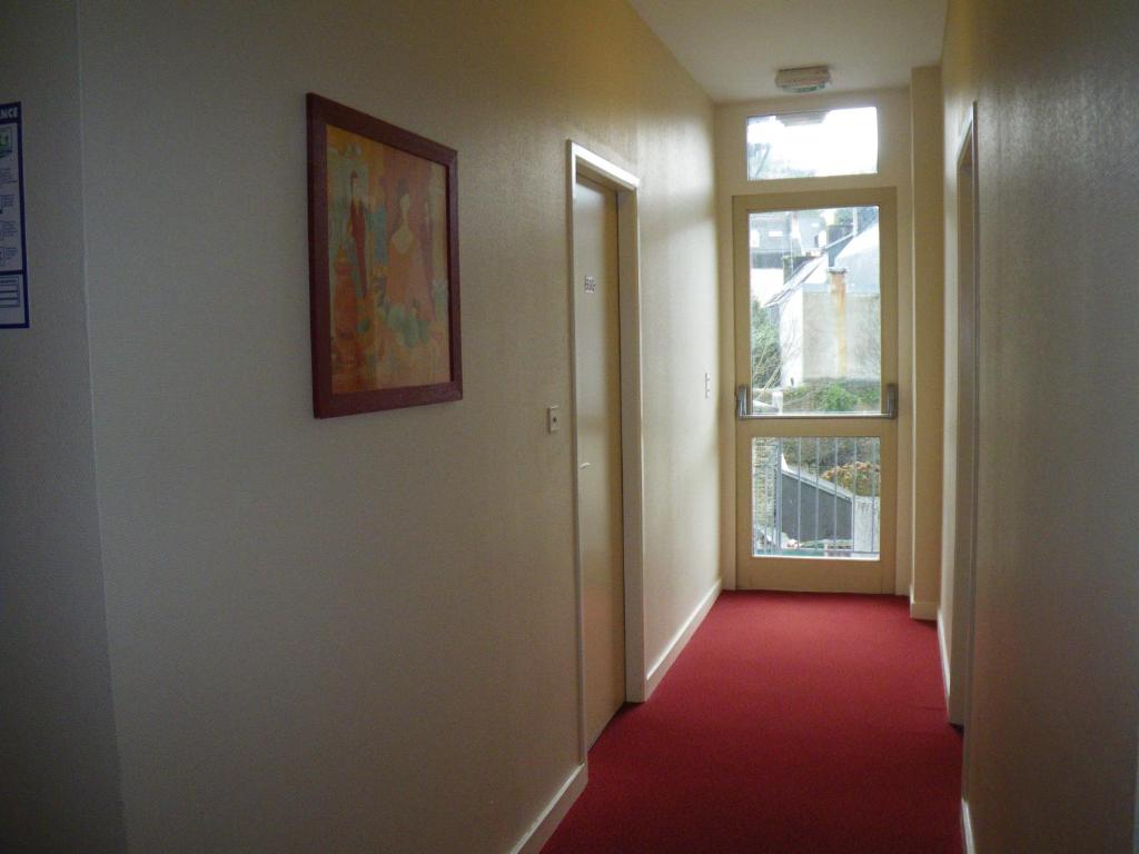a hallway with a window and a red carpet at Hotel TGV in Quimper