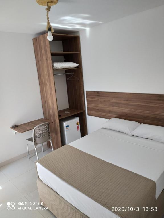 a bedroom with a bed and a desk and a chair at Pousada Verçosa - Rota Ecológica dos Milagres in Passo de Camarajibe