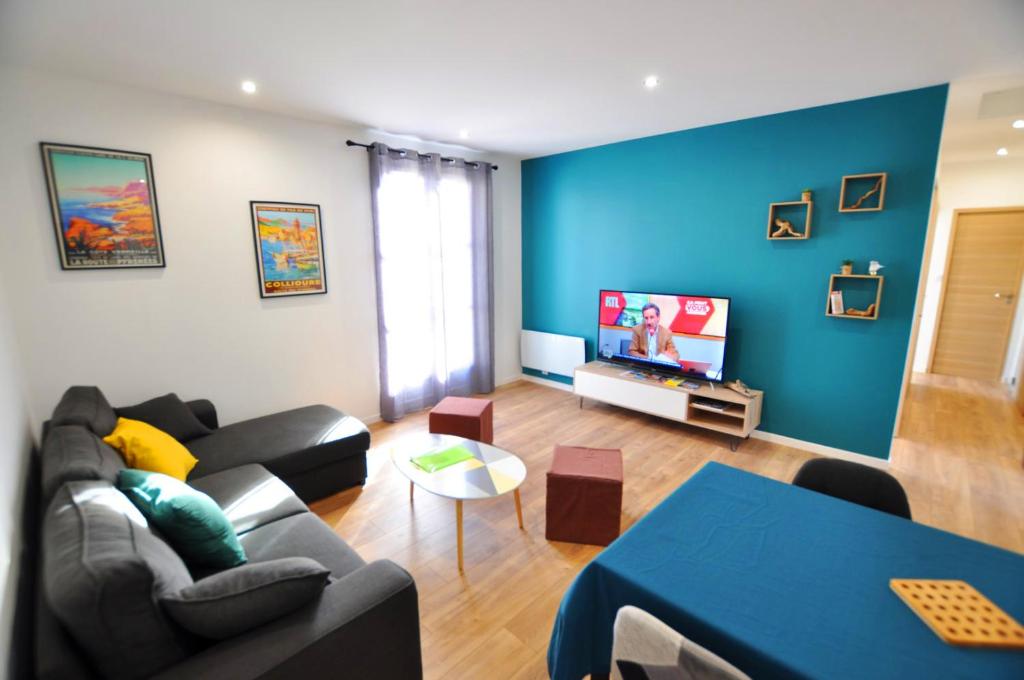 a living room with a couch and a tv at Le Patio - Appartement 2 chambres dans quartier recherché in Perpignan