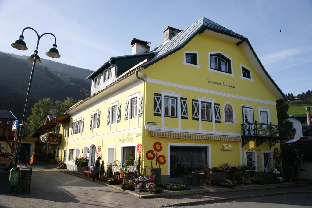 un edificio blanco y amarillo en una calle en Ferienappartement Royer, en Schladming