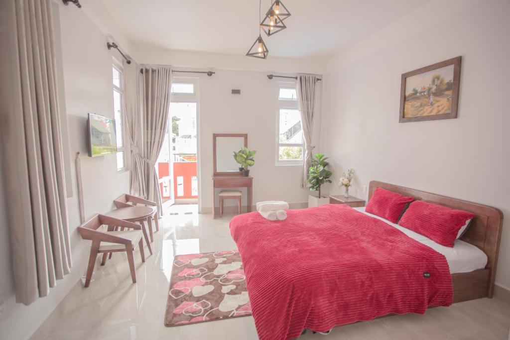 ein Schlafzimmer mit einem Bett mit einer roten Decke in der Unterkunft Lovely House in Da Lat