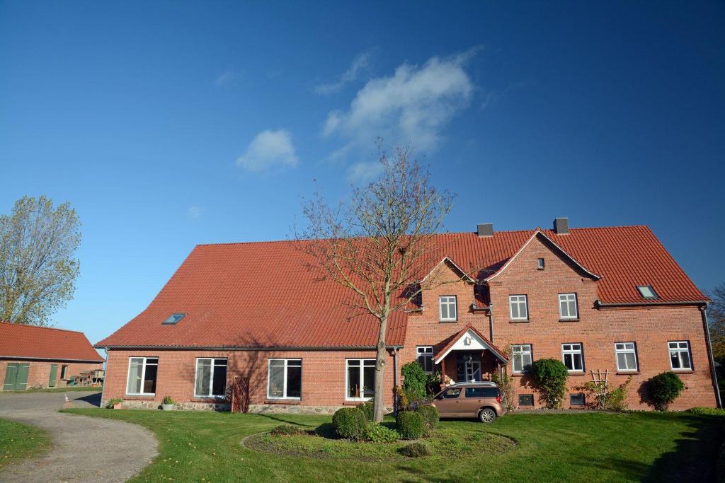 a large brick house with a red roof at Hof Brinker - Kornspeicher in Boiensdorf