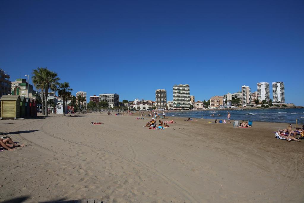 um grupo de pessoas deitadas na praia em Apartamento caribe em Oropesa del Mar