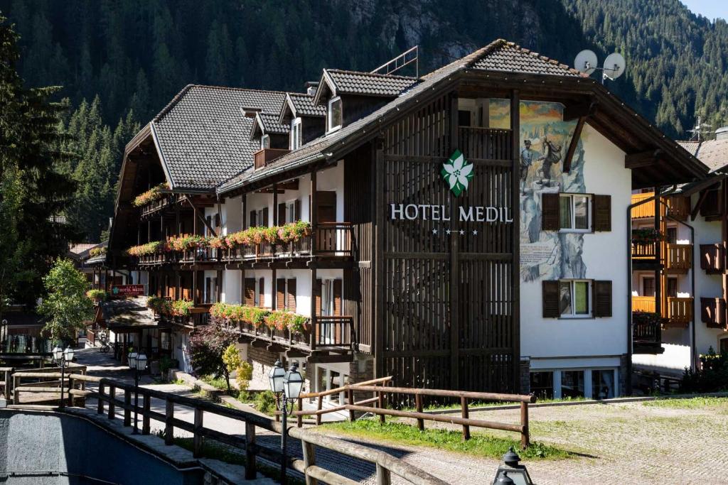 a large building with a clock on the top of it at Hotel Medil in Campitello di Fassa
