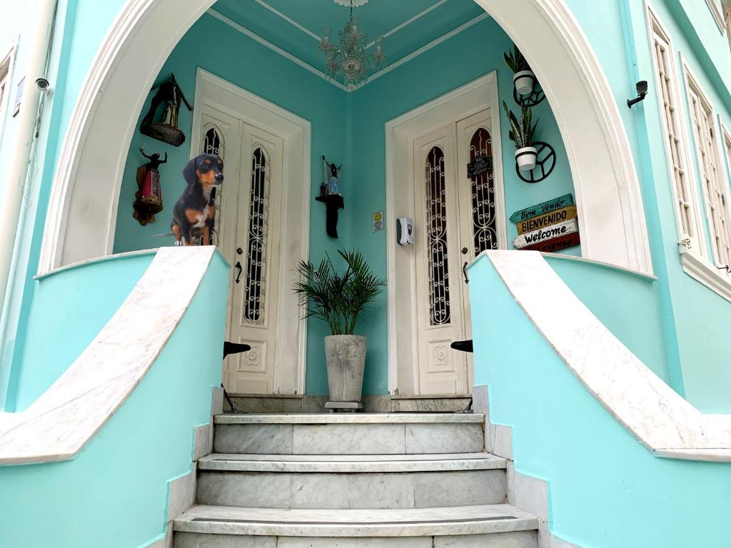 uma escada que leva a uma casa com paredes azuis em Porto das Palmeiras Hostel em Salvador