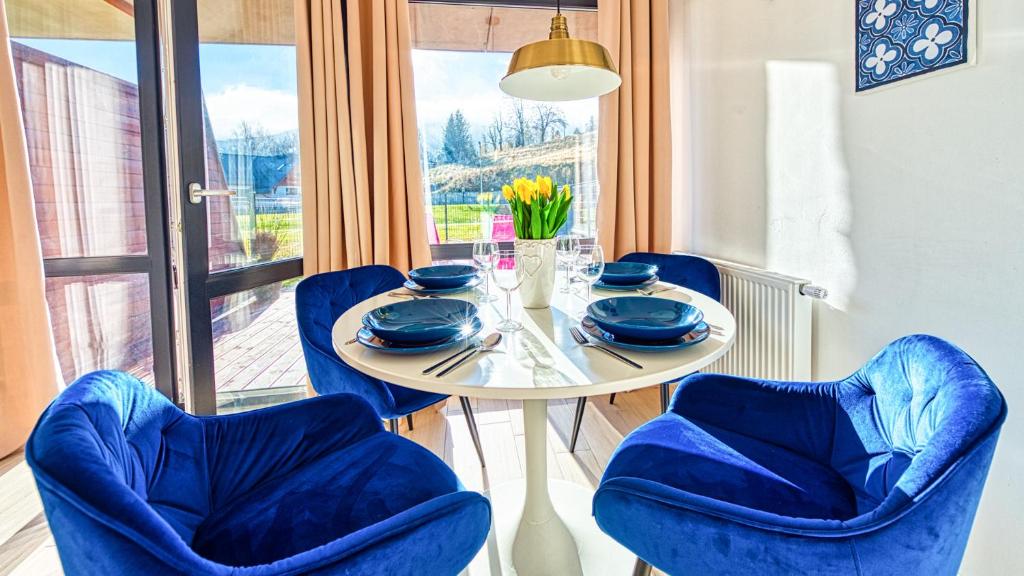 d'une salle à manger avec une table, des chaises et une fenêtre. dans l'établissement Apartament Triventi 48 Premium SPA - 5D Apartamenty, à Karpacz